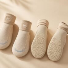 Koelende hondensokken – bescherming tegen zomerhitte Vier beige hondensokken met antislip‑zool en logo, plat gelegd op lichte achtergrond